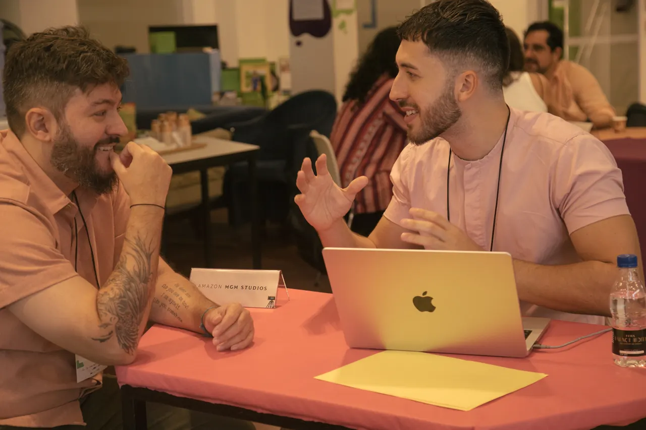 Duas pessoas conversam em uma mesa de atendimento