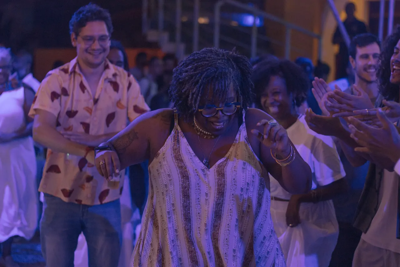 Pessoas dançando e batendo palmas em um evento à noite