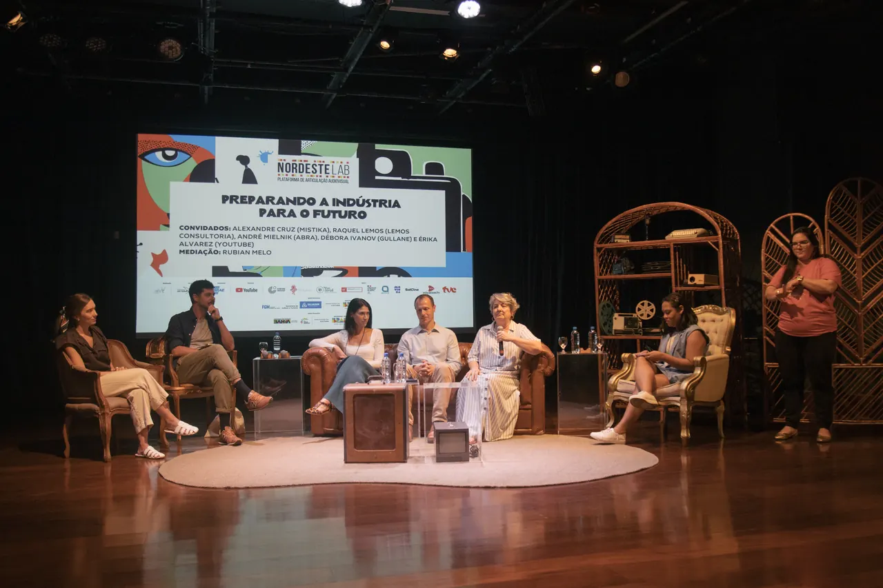 Mesa de debate no palco, diante do telão do NordesteLAB