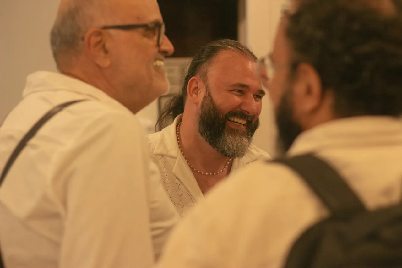 Três homens conversam e riem