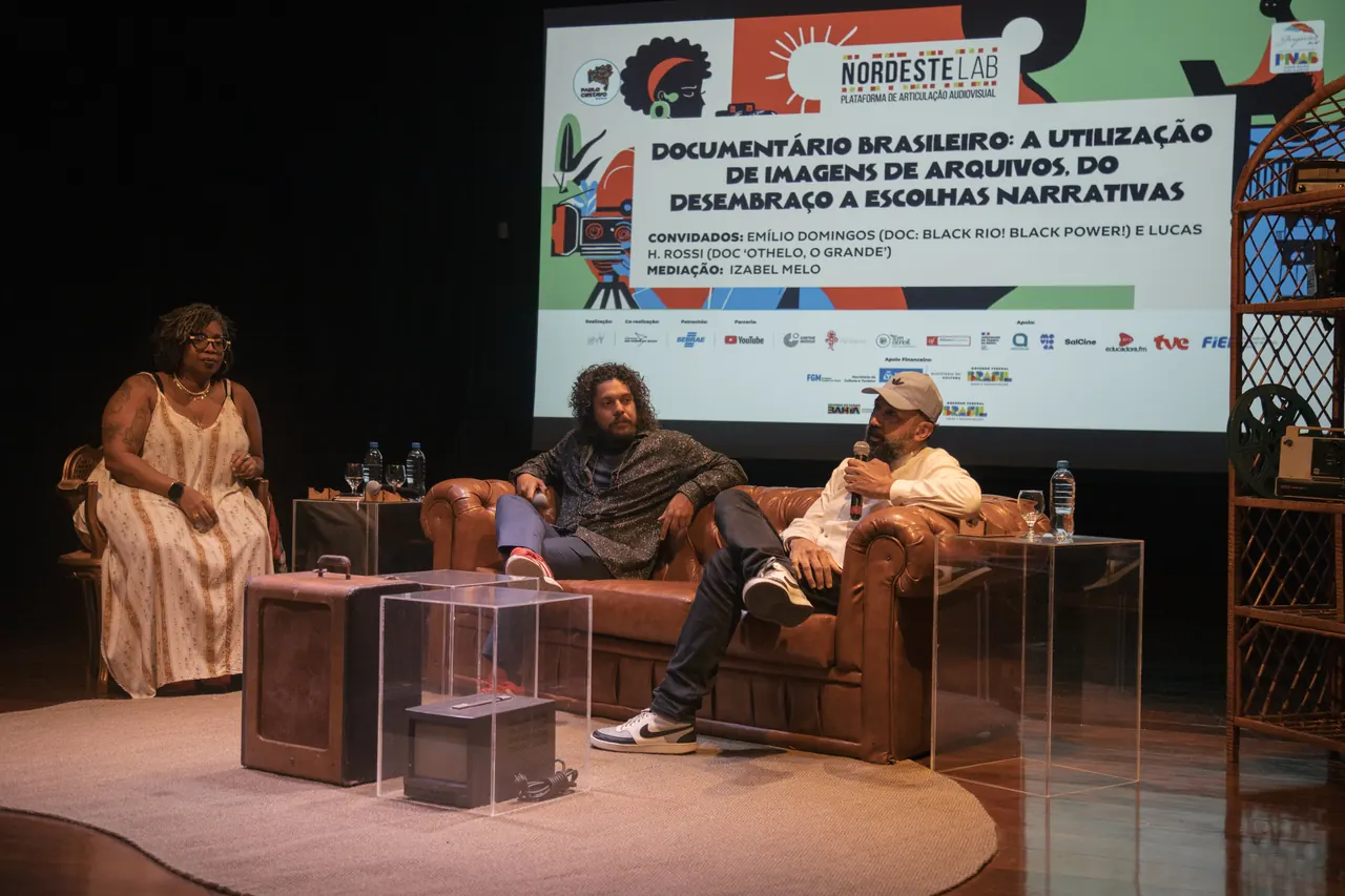 Mesa de debate no palco, com telão ao fundo